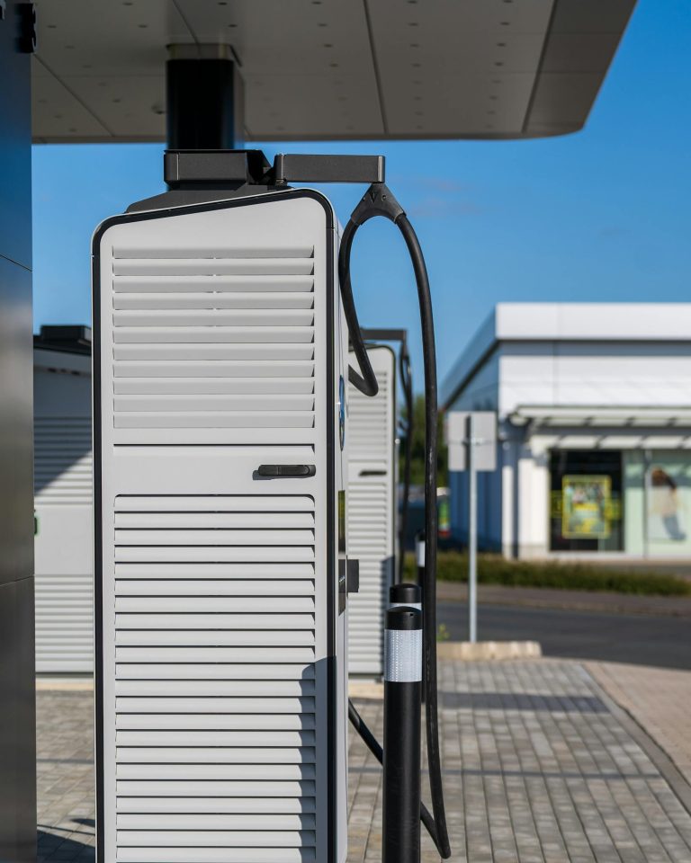 Electric vehicle charging station on a sunny day, showcasing sustainable urban technology.